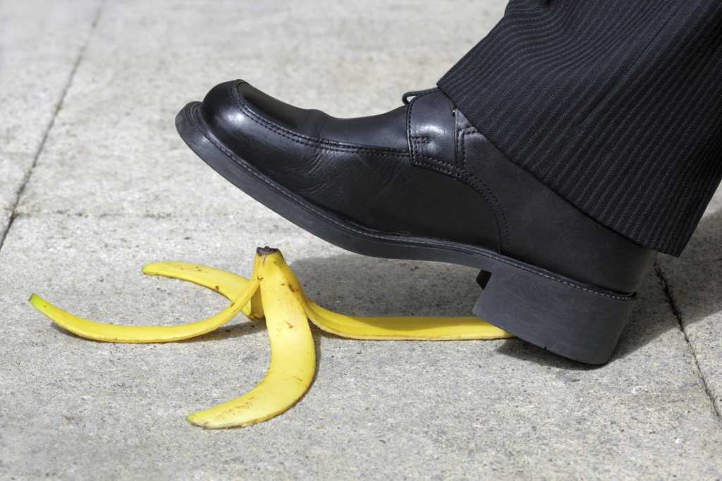 businessman foot stepping on banana peel