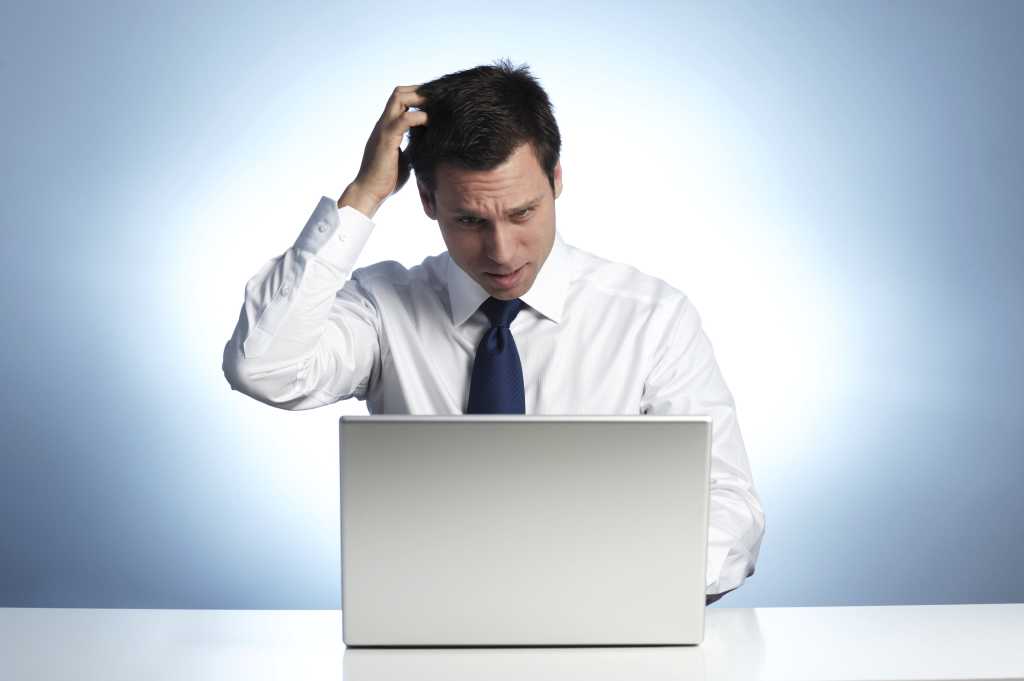 It worker scratches head while viewing laptop computer 111874294