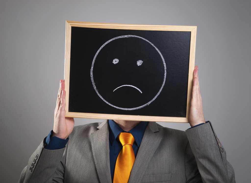 Man with sad face on chalkboard