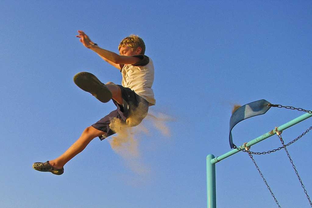 boy jumping off swing