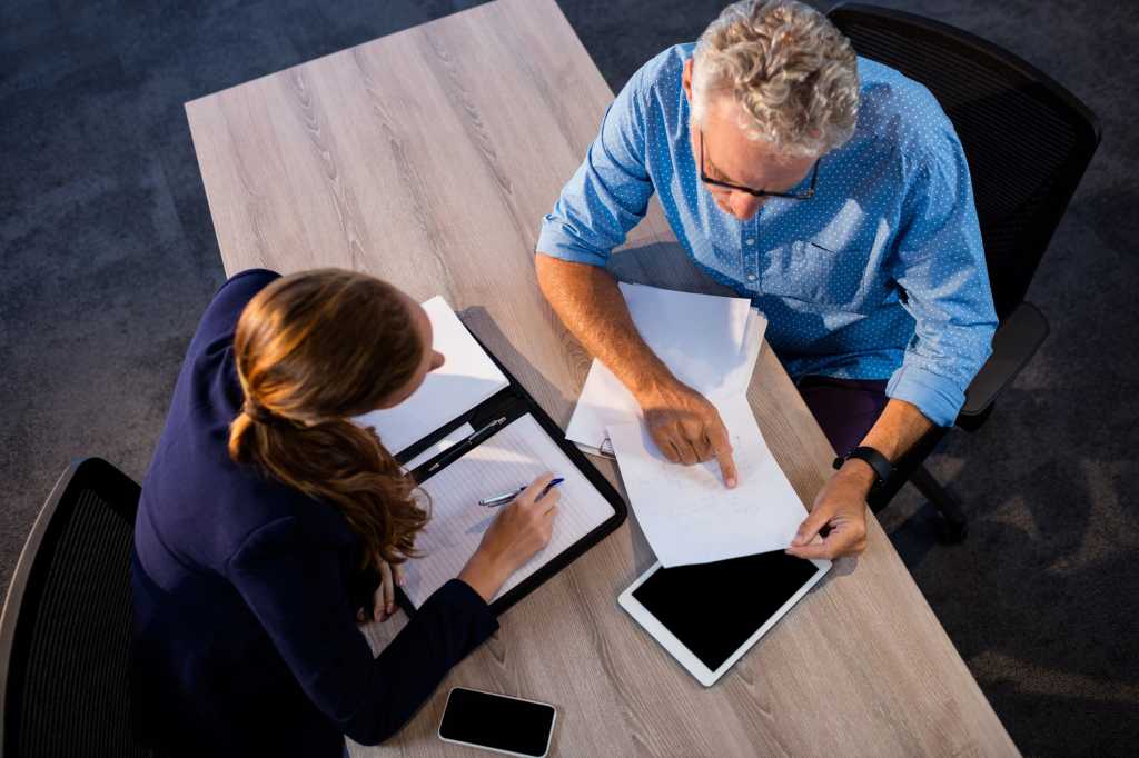 businesspeople review paperwork contract