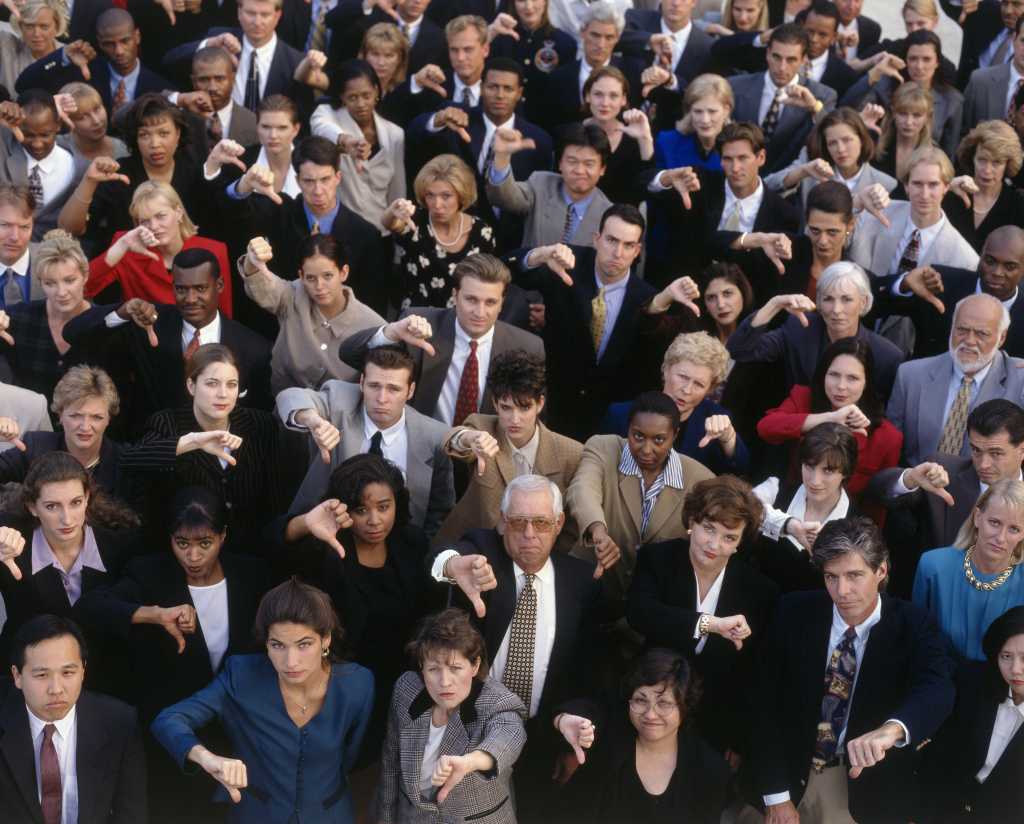 crowd of business executives disapprove thumbs down