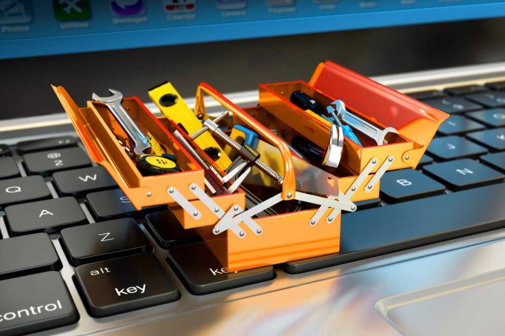 Miniature tools + toolbox toolkit on a laptop keyboard.