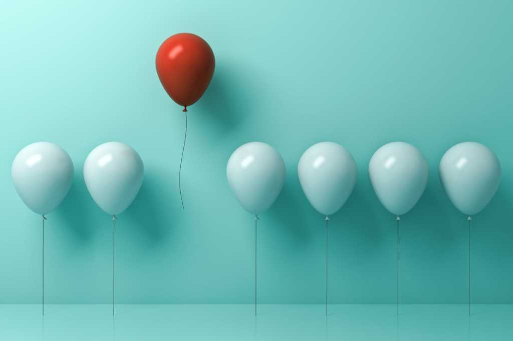 one red balloon rises above a line of white balloons