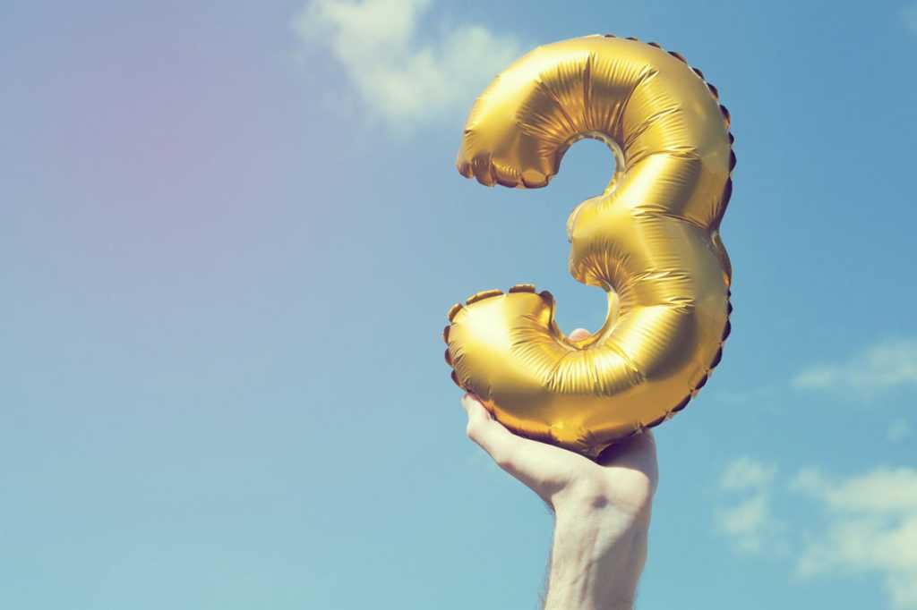 hand holding gold number 3 balloon top three