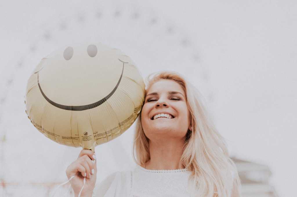 happy woman with smiley face balloon emoji content smiling laughing by pexels