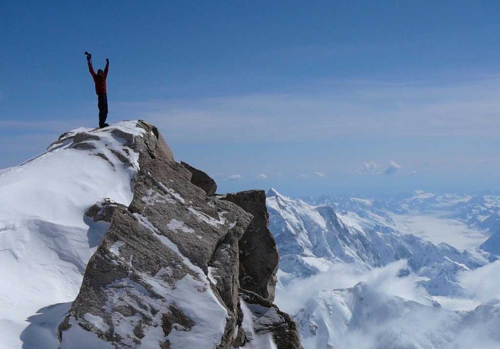 hiker at the mountain top journey mission accomplished