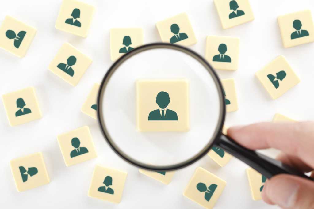 human resources employees examine magnifying glass