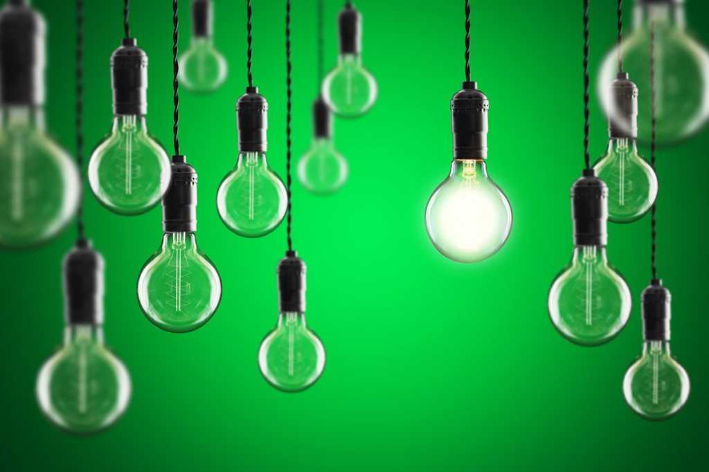 one lit hanging bulb among many unlit ones