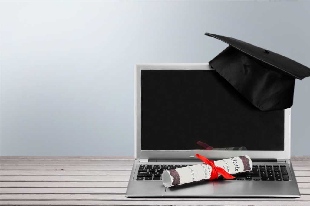 laptop with mortarboard and diploma certificate