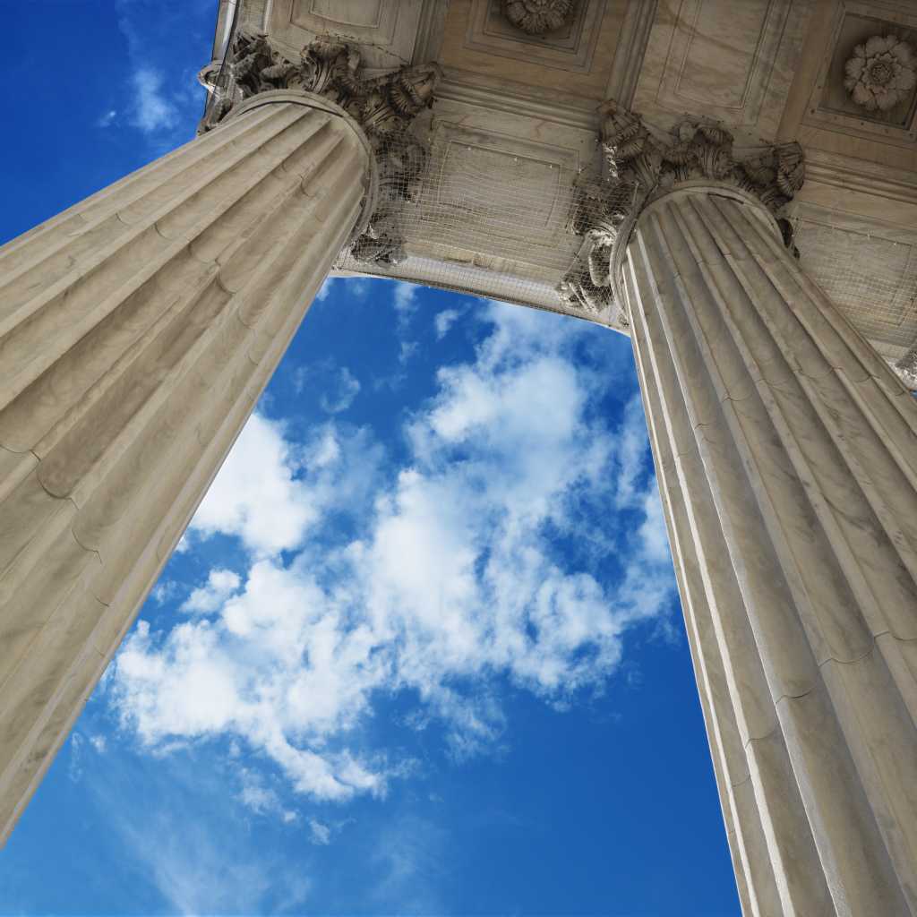 low angle view looking up at blue sky with clouds and columns of supreme court building in washingt