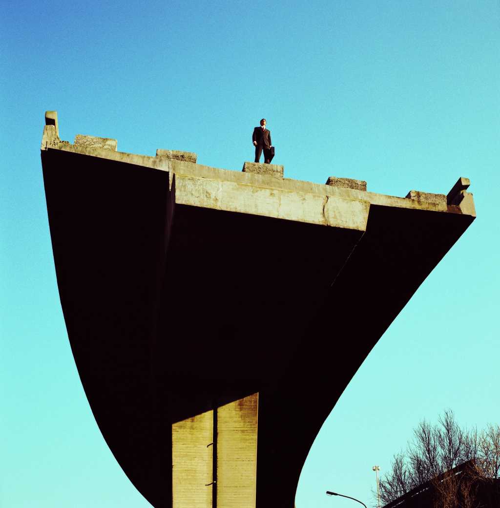 low angle view of a businessman standing atop an incomplete bridge stk33345bin