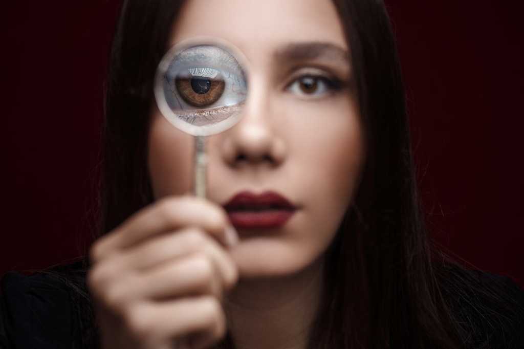 magnifying lens held to eye / inspection / analysis