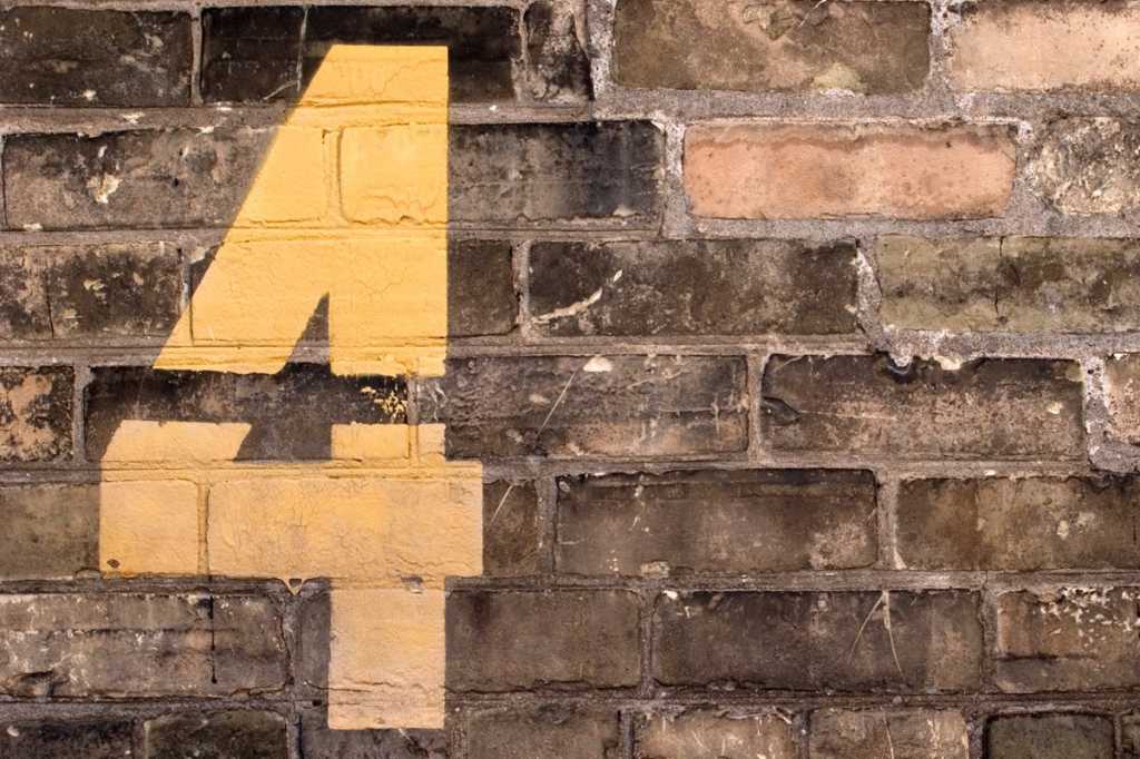 number 4 on painted on brick wall four