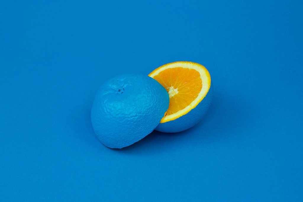 an orange with a blue rind on a blue background / unexpected/ surprise / change / transformation