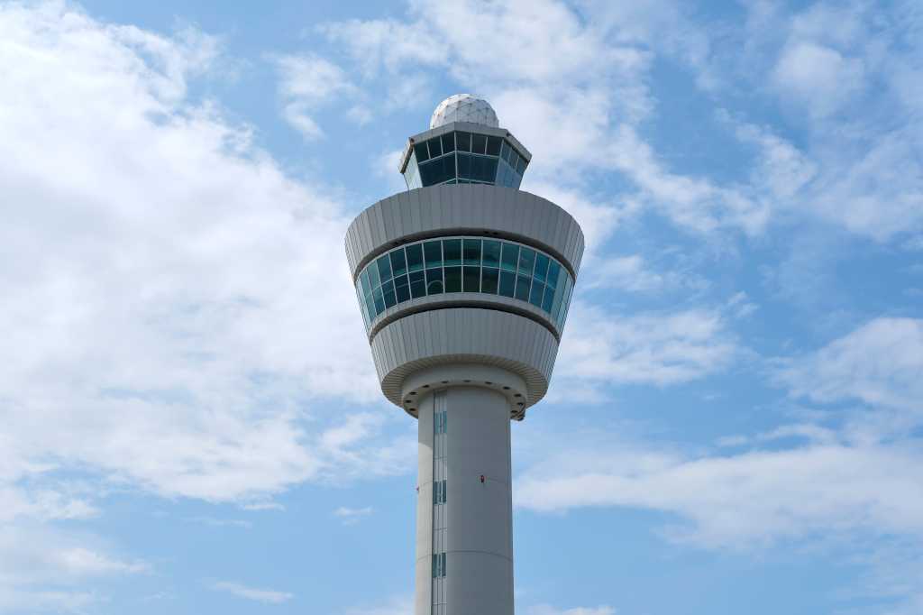shutterstock 2346426015 air traffic control tower in Netherlands airport against cloudy blue sky