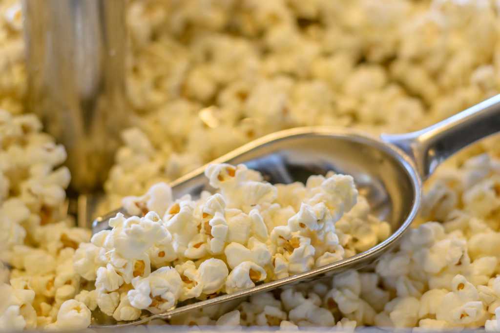 shutterstock 420429250 popped popcorn in metal scoop in popcorn machine