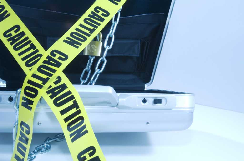 steel briefcase with chains and yellow caution tape