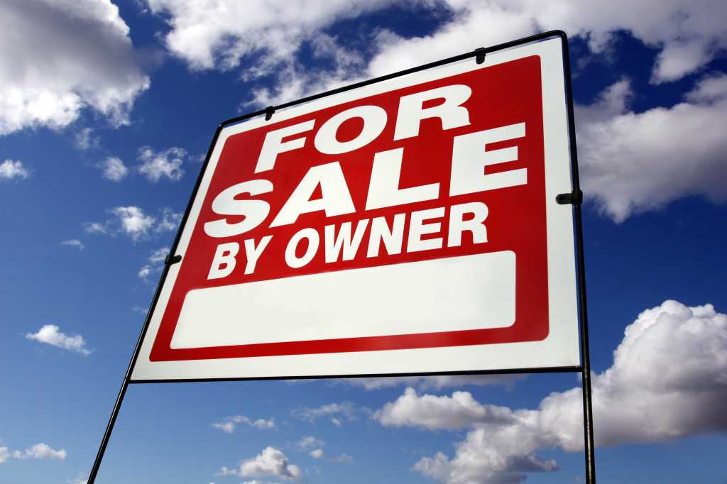 For Sale sign against blue sky and clouds