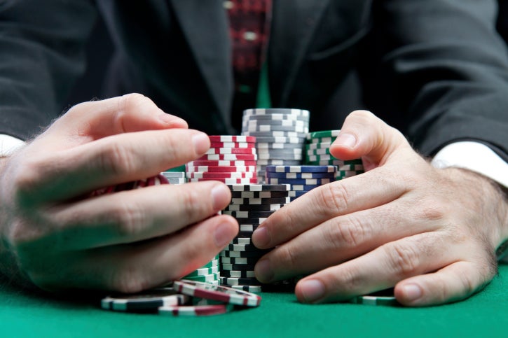 man in suit collecting poker chips