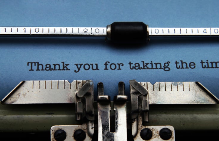 typewriter with blue paper and thank you note