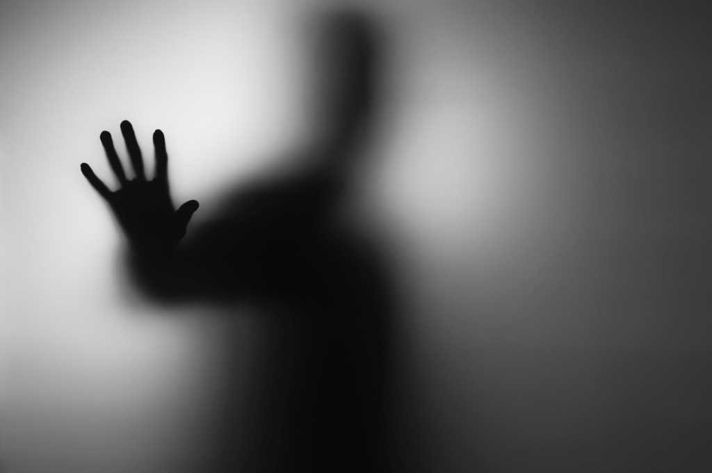 shadowy figure reaching out of blurred background