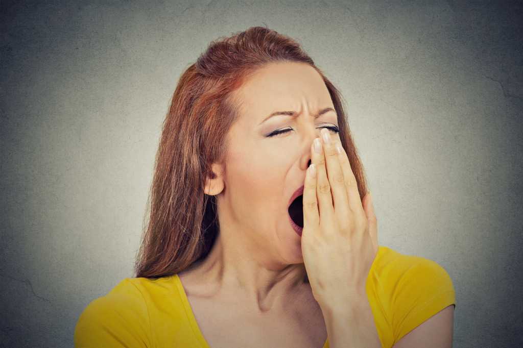 Woman in yellow shirt yawning