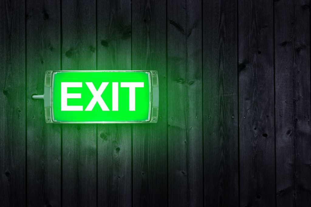 Green glowing exit sign again wall