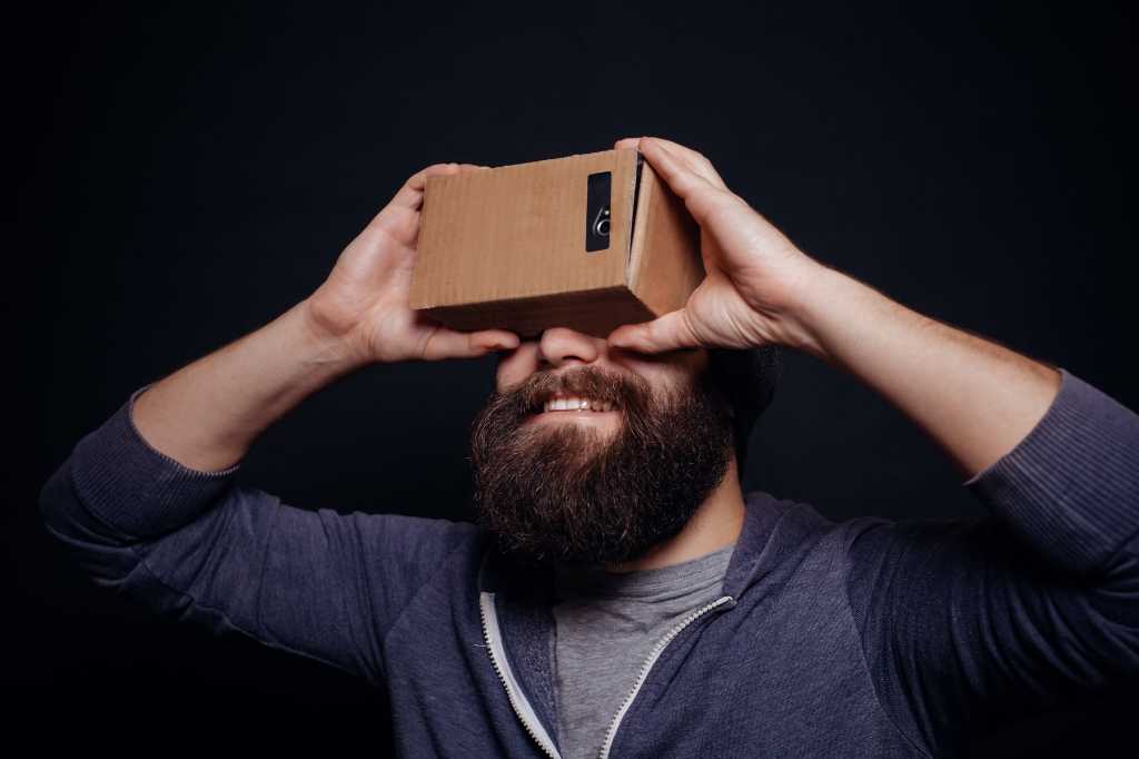 Hipster millennial holding a homemade virtual reality mask