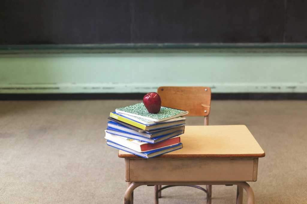 classroom with child's desk and stack of books