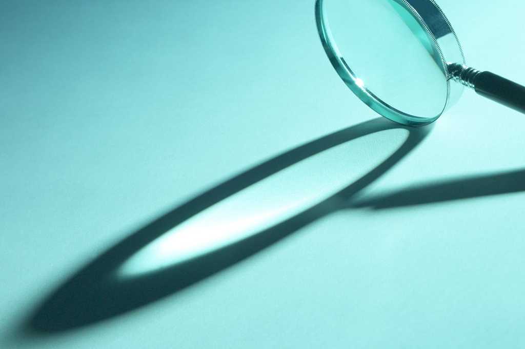 magnifying glass on teal background with shadow