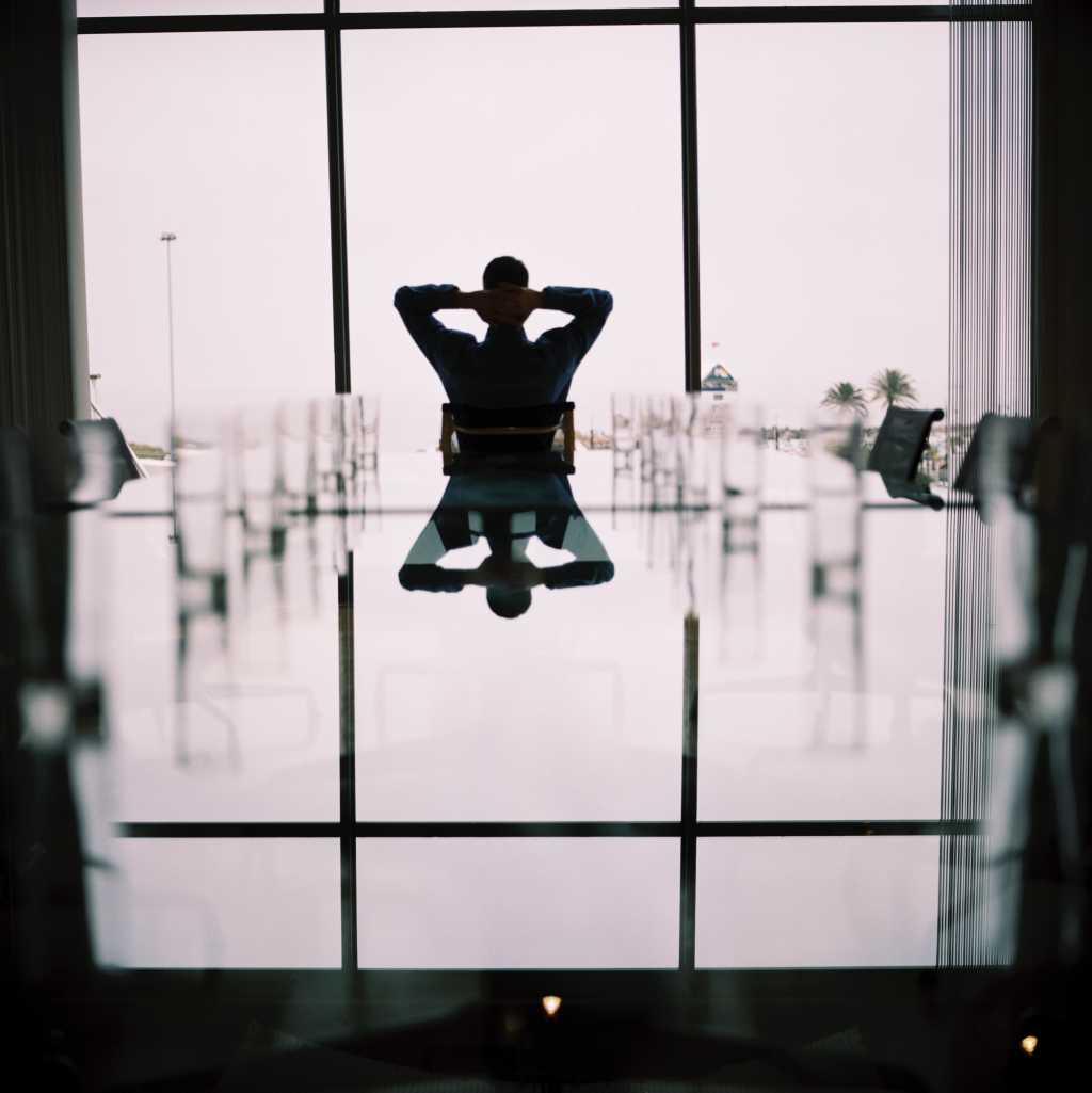 view of a businessman relaxing at the head of a conference table stk32399bme
