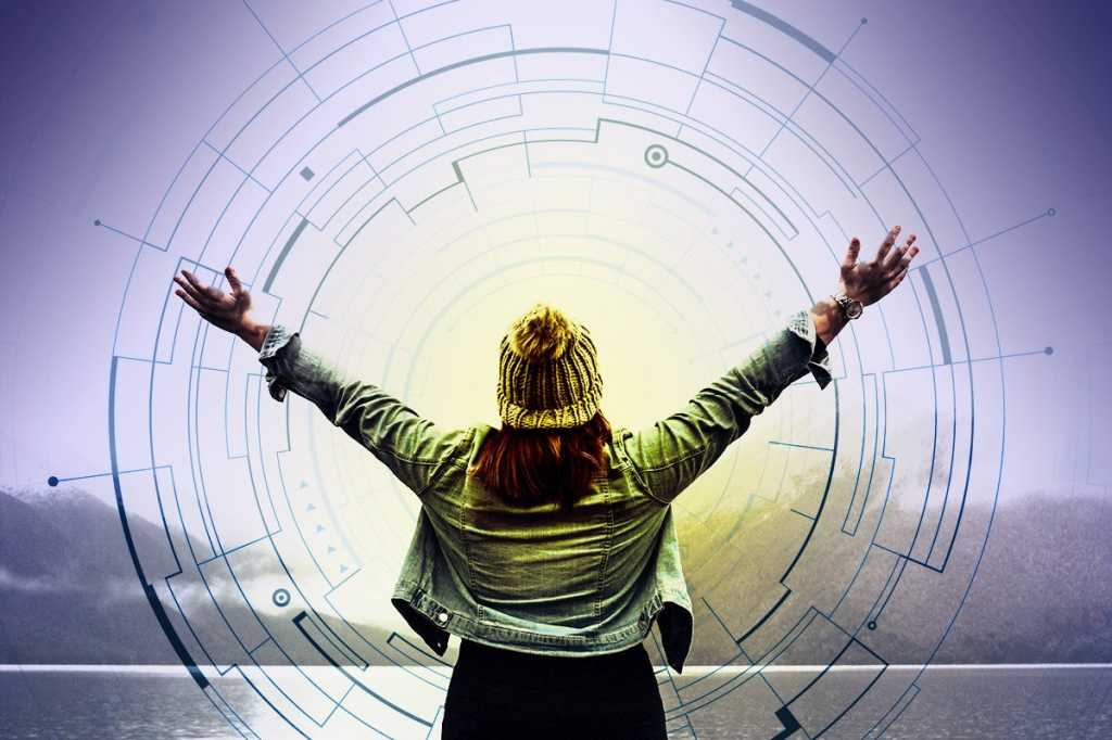 A woman, arms raised, at water's edge. / success / achievement / freedom / digital transformation