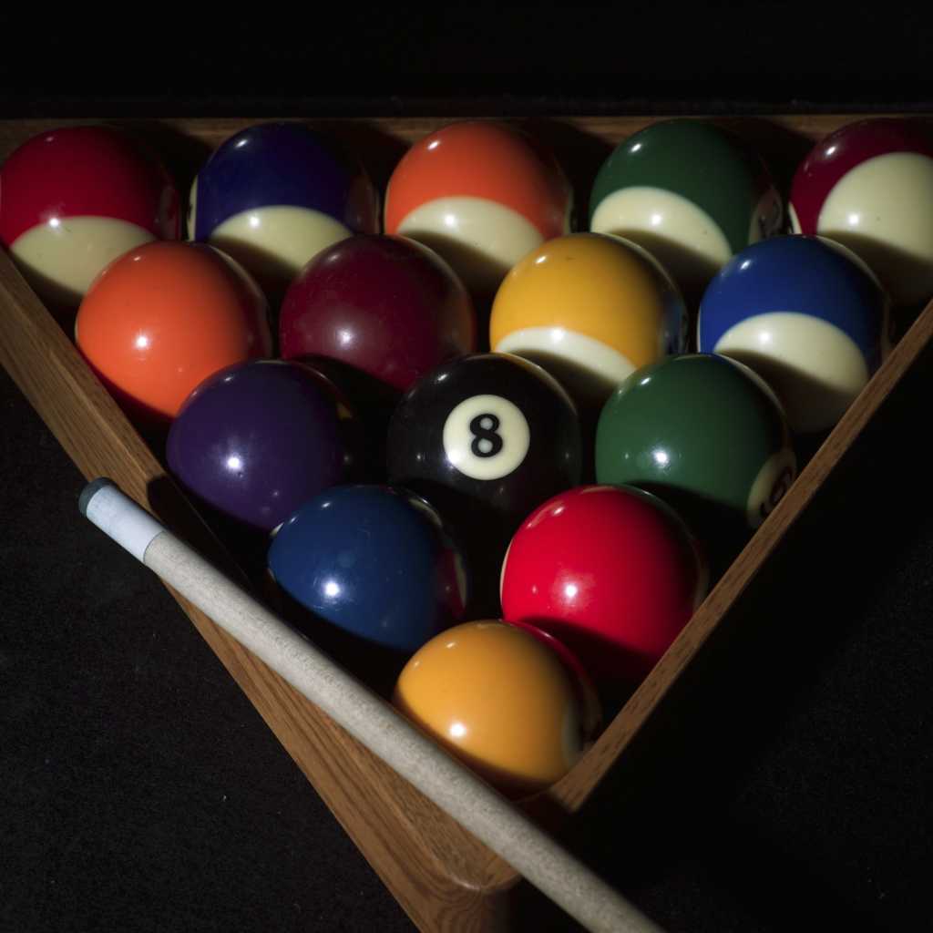 pool balls in a rack with a pool cue 122418479