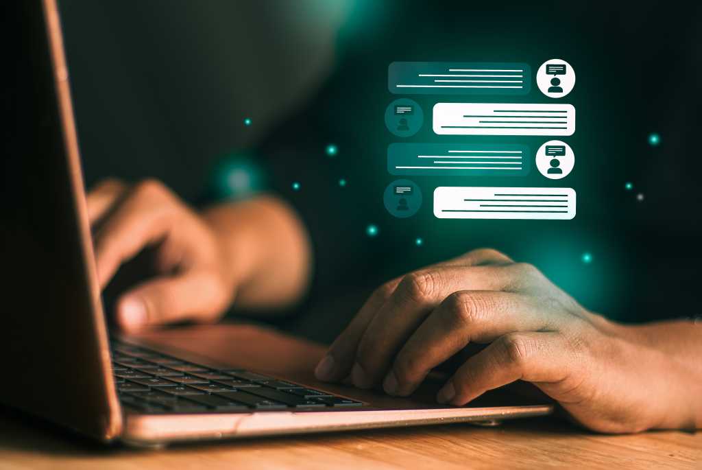 A user at a laptop interacting with a virtual agent. Conversational AI, chatbot.