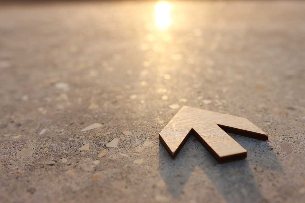 Arrow pointing to the horizon and rising sun. Future, look ahead.