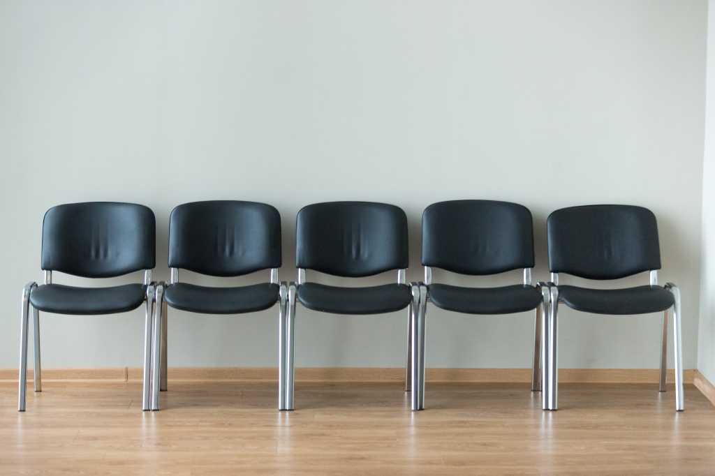 shutterstock 1191901810 row of emptyblack office chairs outside conference room or interview room