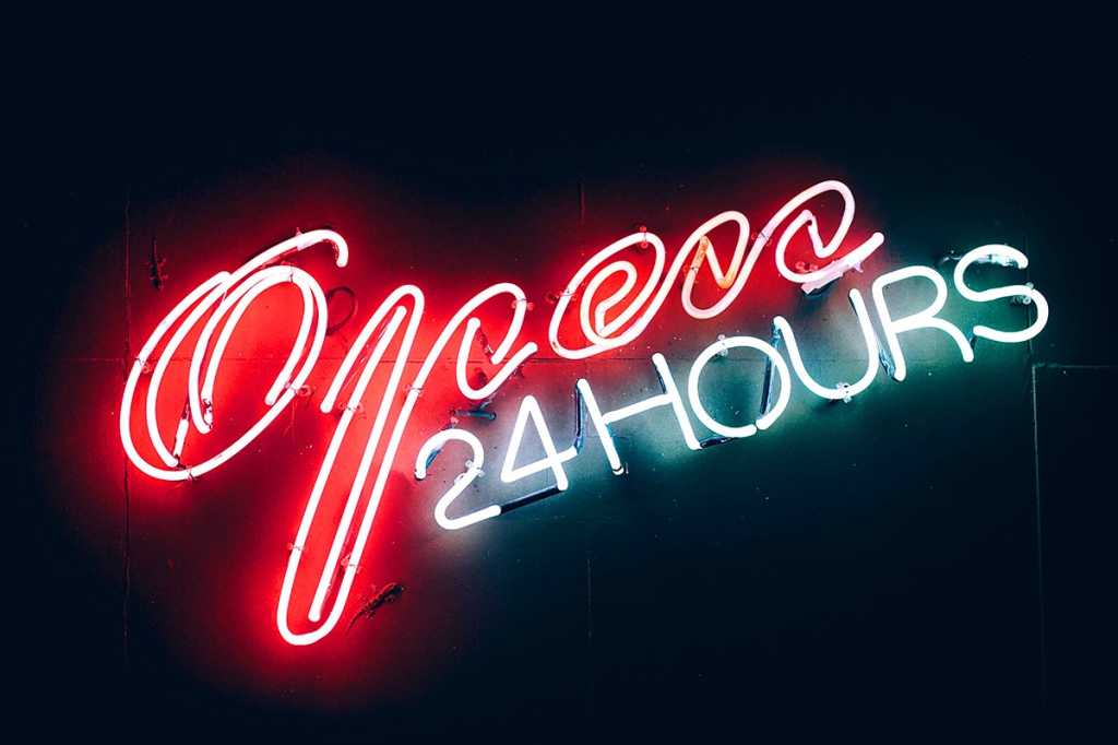 A neon sign reads, 'Open 24 Hours.'