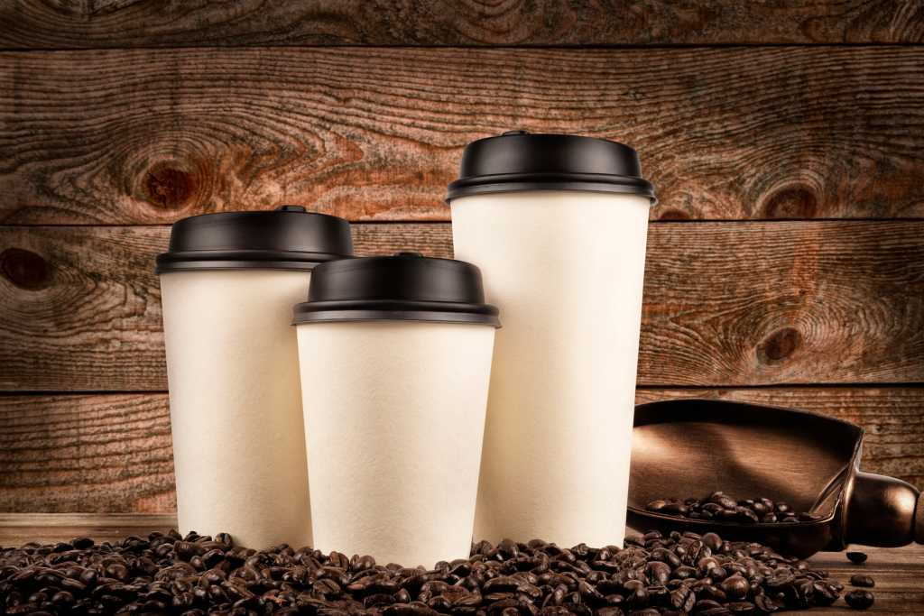 shutterstock 782278819 small medium large cups of coffee and coffee beans on old wooden background.