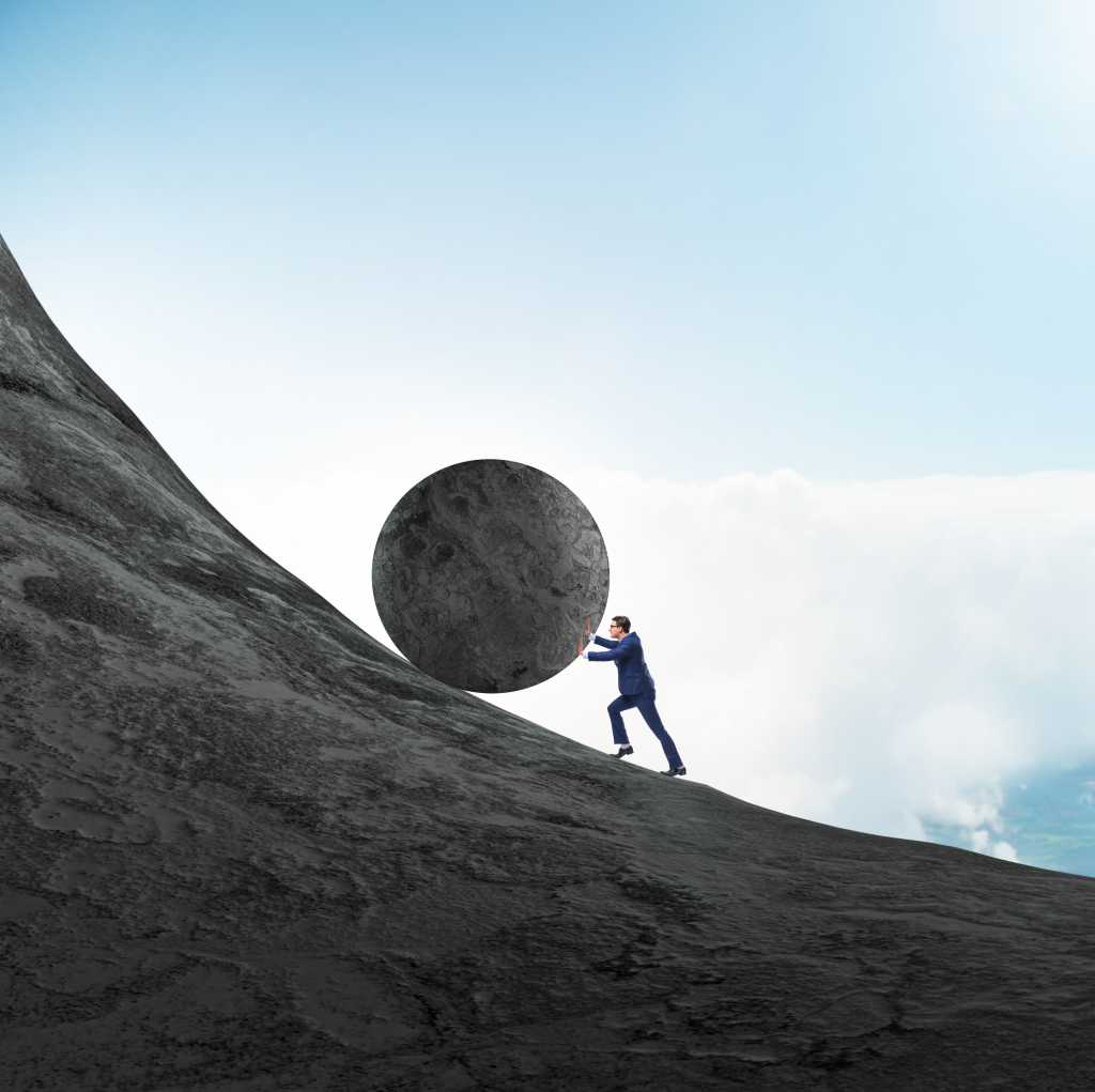 Man pushing a large boulder up a mountain.