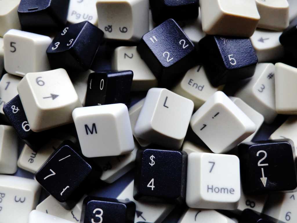 Black and white computer keyboard keys, mostly numeric with M and L (machine learning) keys in foreground. Concept of unstructured big data for data science and deep learning.