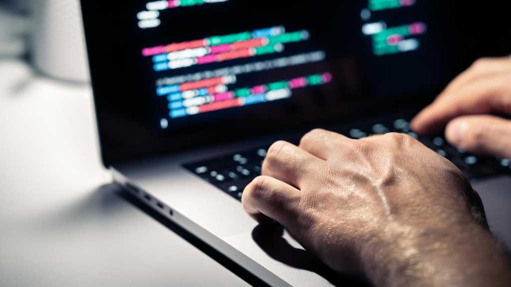 Hacker mit Malware-Code im Computerbildschirm. Cybersicherheit, Datenschutz oder Cyberangriff. Programmierer oder betrügerische kriminelle Schreib-Virus-Software. Online-Firewall und Datenschutzkriminalität. Webdateningenieur.