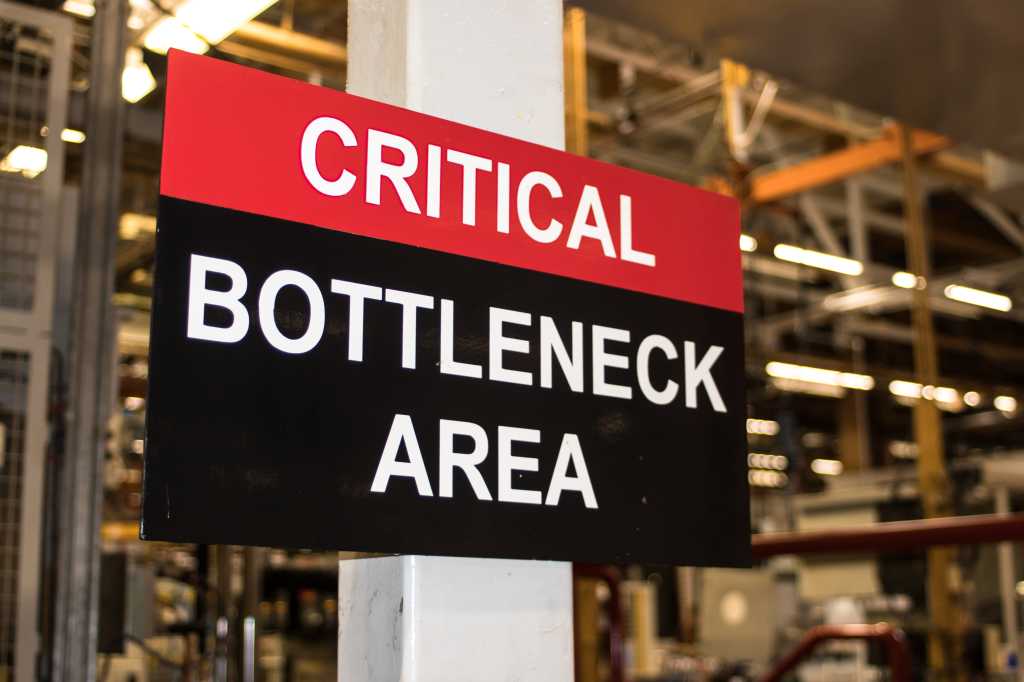 Critical Bottleneck Area sign in industrial factory setting