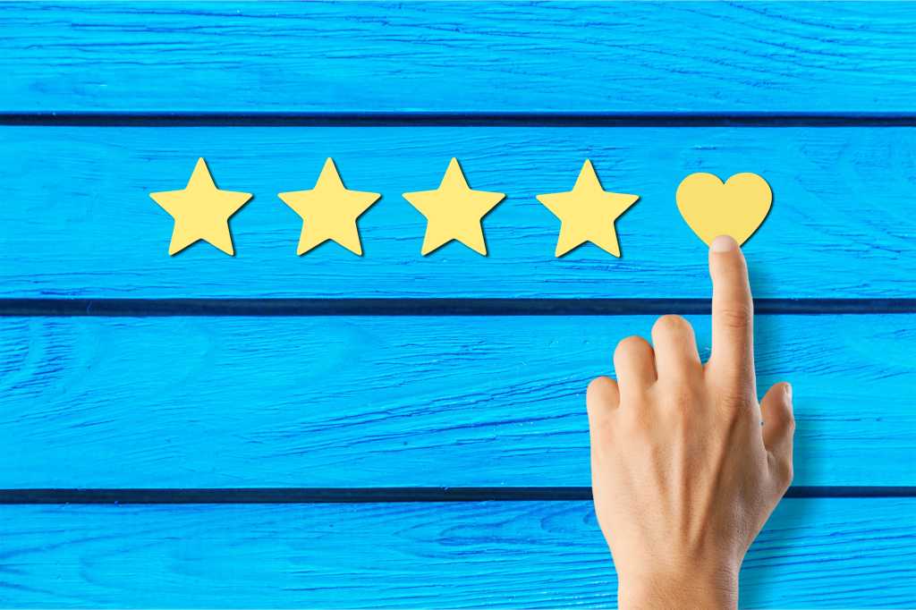 Four paper-cut gold stars and one heart on a blue painted fence background.