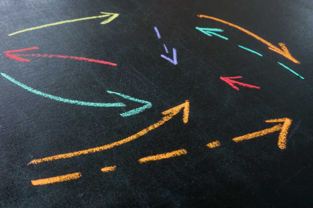 Abstract arrows drawn with colored chalk as a concept of interaction and complex relationships in a company.