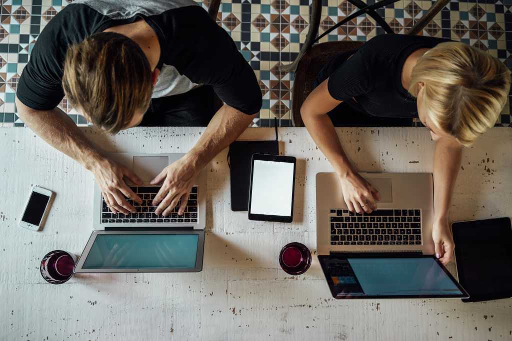 Coworkers using Mac laptops shot from above