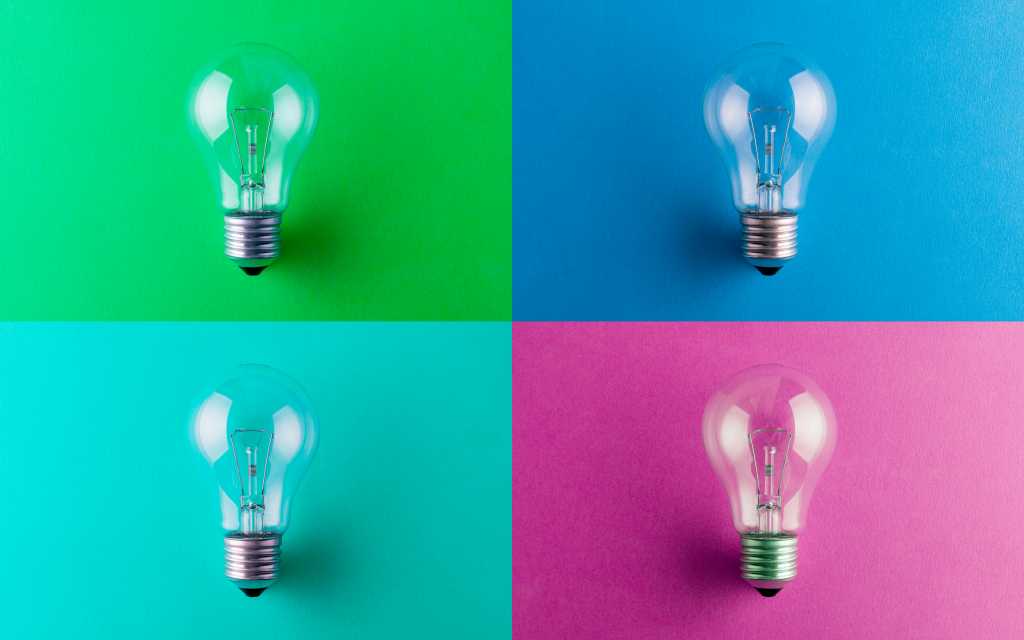 Four light bulbs 4 light bulbs against green blue aqua and pink colored squares