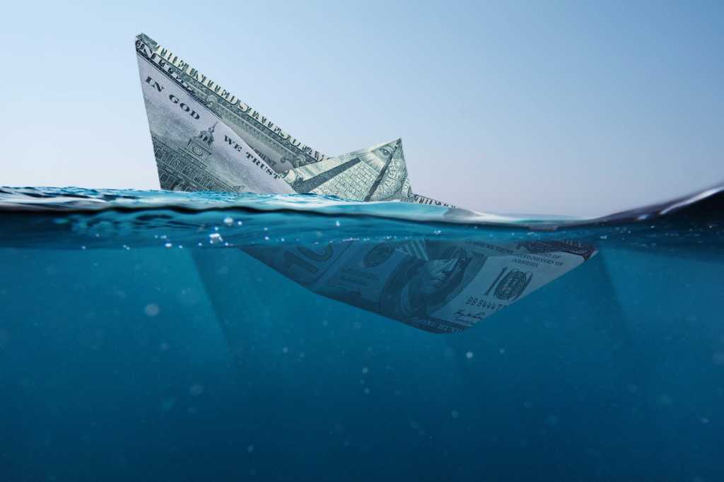 Concept paper dollar boat sinking in the sea with a view underwater. Finance and crisis, a creative idea. Falling exchange rates. Insurance