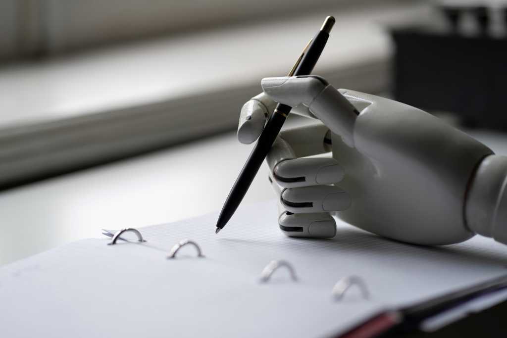 artificial robotic arm write down some notes with pen