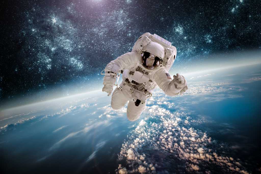 Astronaut in outer space against the backdrop of the planet earth. Elements of this image furnished by NASA.